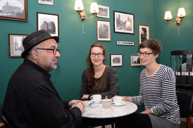 Werkstattfilm-Leiter Farschid Ali Zahedi, Stella Rüger und Yvonne Resch im Café des KinOLadens vor Fotografien aus den 20er Jahren.