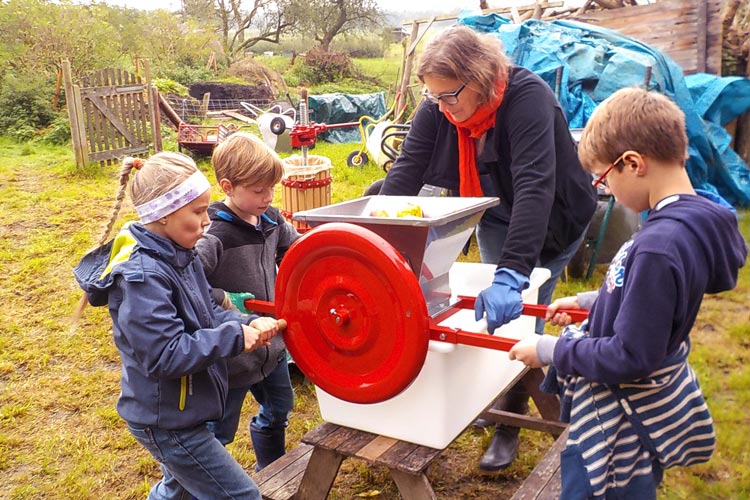 Antje Bruns-Osolin mit Schülern an der Hand-Obst-Mühle.