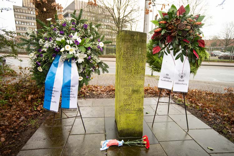 Kränze an dem Gedenkstein zur Erinnerung an die 74 Deportierten und Ermordeten Sinti und Roma aus Oldenburg.