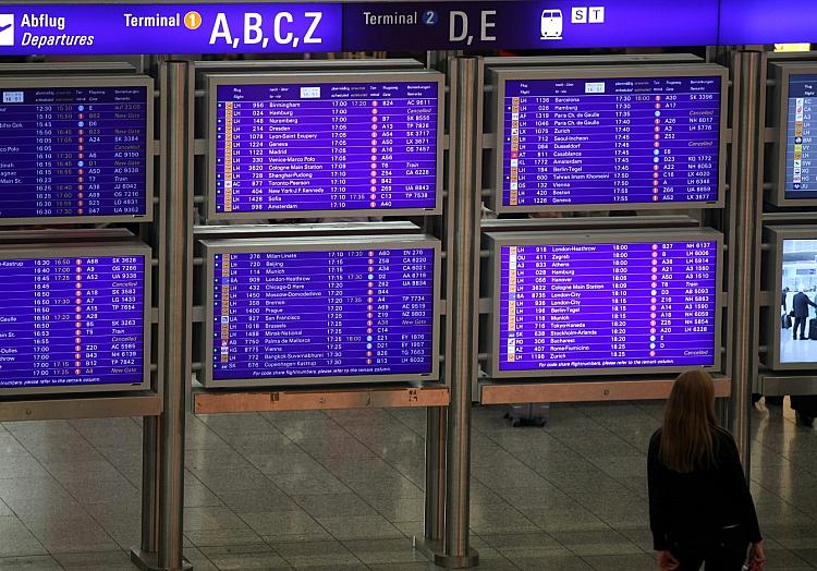 Frau vor Informationstafel am Frankfurter Flughafen, via dts Nachrichtenagentur